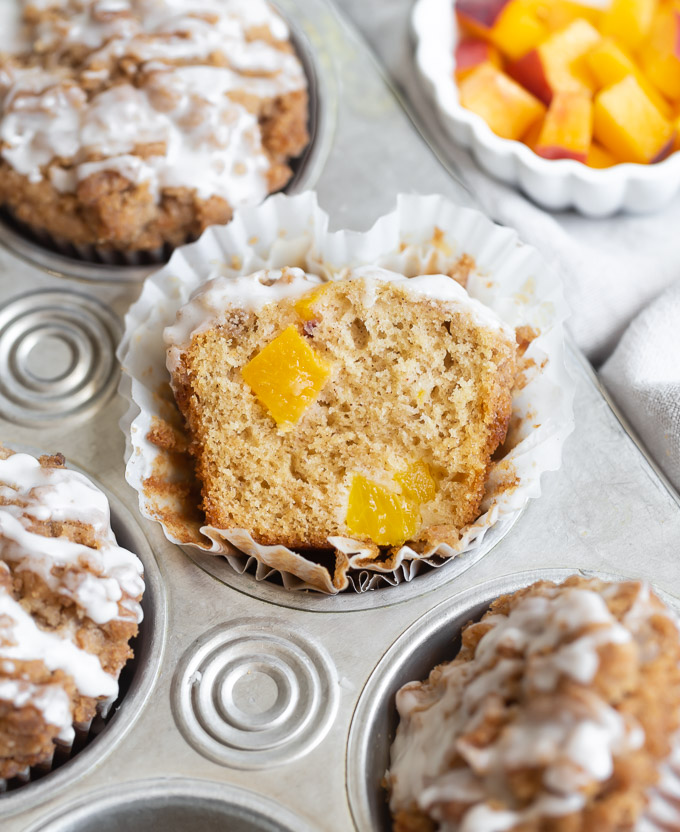 cross section of peach streusel muffin in muffin tin